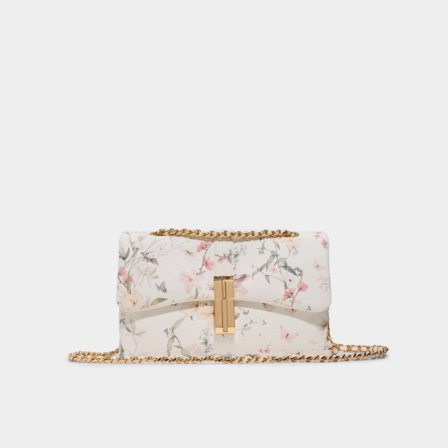 Floral patterned handbag with gold chain on a white background