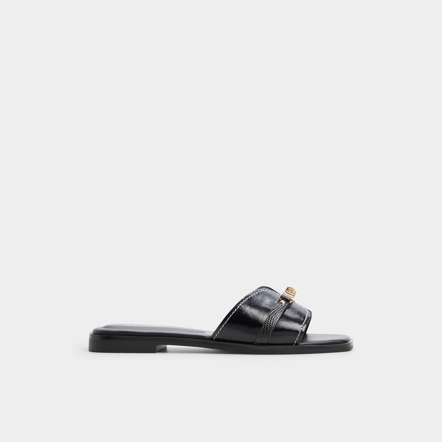 Black slide sandal with gold buckle on a white background