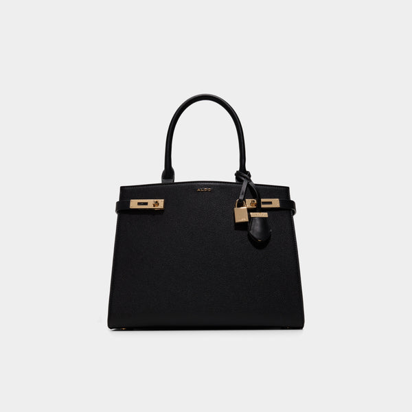 Black handbag with gold hardware on a light gray background